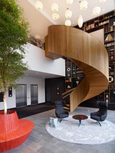 a staircase in a lobby with chairs and a table at citizenM Rotterdam in Rotterdam
