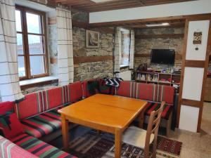 ein Esszimmer mit einem Tisch und roten Kabinen in der Unterkunft Discover Strandja House in Kosti