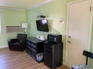 een hotelkamer met een tv en een stoel en een kamer bij Lake Inn in Ebensburg