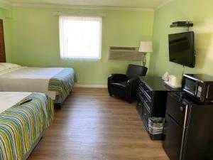 Cette chambre comprend un lit et une télévision. dans l'établissement Lake Inn, à Ebensburg