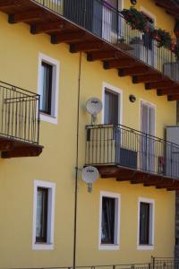 a yellow building with windows and balconies on it at Eleonora’s Home in Aosta