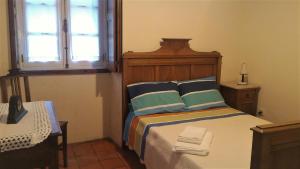 a bedroom with a bed with a wooden headboard and a window at Cottage - Vitorino dos Piães in Vitorino dos Piães