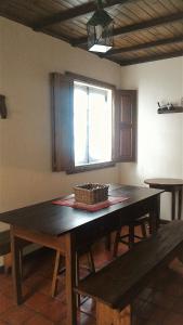 Cottage - Vitorino dos Piães في Vitorino dos Piães: غرفة طعام مع طاولة خشبية ونافذة