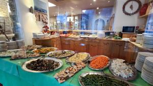 a buffet of food on a table with plates of food at Hotel Principe Marmolada in Malga Ciapela