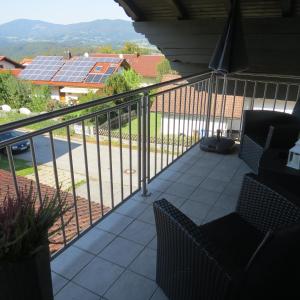 a balcony with a view of a house with solar panels at Wohlfühlapartment Erlenberg in Thurmansbang