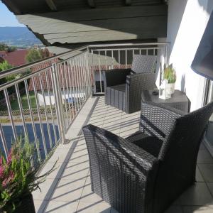 a patio with two chairs and a table on a balcony at Wohlfühlapartment Erlenberg in Thurmansbang