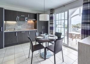 a kitchen and dining room with a table and chairs at Les Villas du SPA in Pléneuf-Val-André +17 photos