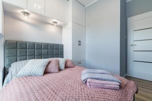 a bedroom with a large bed with pink blankets at Apartament36-1c Calamo Park in Olsztyn