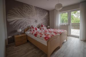 een slaapkamer met een bed met een rode en witte deken bij Ferienwohnung Haus Handwerk in Duppach
