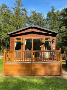 einen Pavillon mit einer Veranda und einer Terrasse in der Unterkunft Tranquil Lodge hot tub and free golf in Swarland