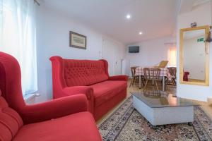 a living room with a red couch and a table at Orgona Vendégház in Murakeresztúr