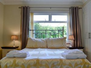 a bed with two towels on it in front of a window at Tan y Gaer in Aberystwyth