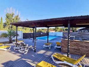 a deck with yellow chairs and a swimming pool at LES JARDINS D'ATHENA in Aix-en-Provence