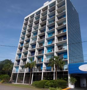 a tall building with palm trees in front of it at Aqua Beach Inn in Myrtle Beach