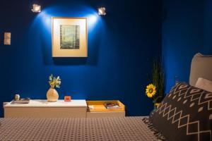 ein Schlafzimmer mit einer blauen Wand, einem Bett und einem Tisch in der Unterkunft Homel Rocks -Elegant Apt 2BD -Amazing garden view in Kalambaka