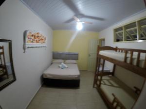 イーリャ・グランデにあるIlha Grande Marの二段ベッド2台、天井ファンが備わる小さな客室です。