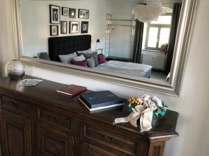 ein Schlafzimmer mit einem Bett und eine Kommode mit einem Spiegel in der Unterkunft Stadthaus Rosengasse in Meißen