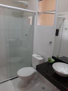 y baño con aseo, lavabo y ducha. en Flats Premium Jabaquara, en Paraty