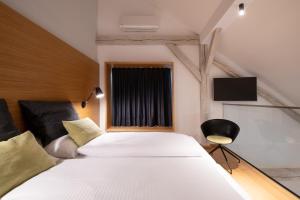 a bedroom with a large white bed and a window at Hotel Thalmair in Munich