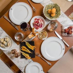 a table topped with white plates and bowls of food at Le Meurice – Dorchester Collection in Paris
