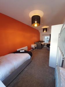 a bedroom with a bed and a orange wall at Large Townhouse in the Heart of Galway No 12 in Galway