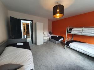 1 dormitorio con 2 literas y pared de color naranja en Large Townhouse in the Heart of Galway No 12 en Galway