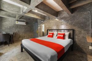 Super OYO 75332 Vm1 Hostel في بانكوك: غرفة نوم بسرير كبير ومخدات حمراء