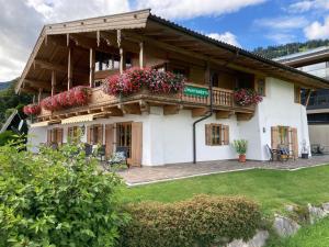uma casa com uma varanda com flores em Landhaus Krall em Brixen im Thale