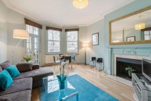 ein Wohnzimmer mit einem Sofa und einem Kamin in der Unterkunft Chelsea - Draycott Place by Viridian Apartments in London