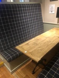 Queenshead Hotel Kelso في كيلسو: طاولة ومقعد أزرق مع طاولة خشبية
