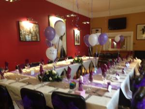 a row of tables in a room with balloons at Queenshead Hotel Kelso in Kelso