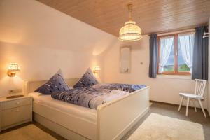 1 dormitorio con cama y lámpara de araña en Ferienhof Wetzel Fewo 2, en Hergensweiler