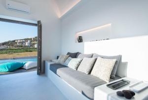- un salon avec un canapé gris et une fenêtre dans l'établissement Luxury Santorini Villa Villa Pori Blanca Master Suite Private Pool and Stunning Sea View Near Pori Beach, à Foinikiá