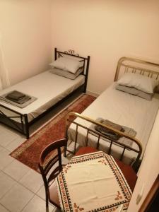two beds in a room with two chairs and a table at BYT Village House in Áyios Khristóforos