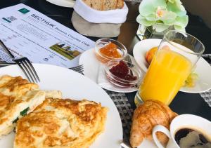 una mesa con platos de comida y un vaso de zumo de naranja en Velich Country Club, en Zvenigorod