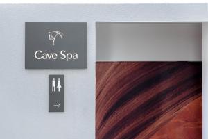 a sign for a cave spa on a wall with brown hair at Glyfada Riviera Hotel in Athens