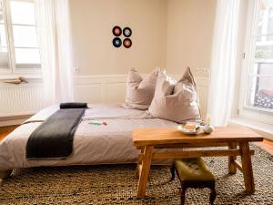 1 dormitorio con cama con almohadas y mesa en altstadtherz en Lindau