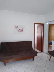 um sofá castanho num quarto com uma porta em Apto no Bairro do Gonzaga em Santos