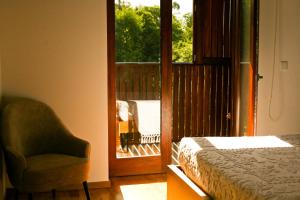 a bedroom with a bed and a chair and a window at Quinta de Barbêdo - Turismo Rural in Caniçada +84 photos