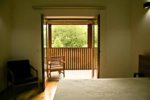 1 dormitorio con 1 cama, 1 silla y 1 ventana en Quinta de Barbêdo, en Caniçada