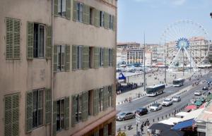 eine Stadt mit einem Riesenrad und einer Straße mit Autos in der Unterkunft Vieux-Port - Magnifique Appartement in Marseille