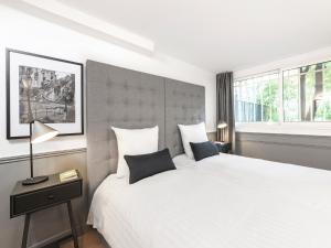 a bedroom with a large white bed and a window at LivinParis - Luxury 3 Bedrooms Arc de Triomphe I in Paris