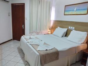 a hotel room with two beds and a window at Arraial do Sol Beach Hotel in Arraial d'Ajuda