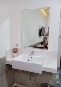 a bathroom with a white sink and a mirror at PETA HOSTEL Bandung in Bandung