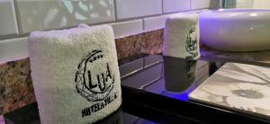 twee handdoeken op een aanrecht naast een wastafel bij Hotel Lua in Mexico-Stad