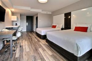 Habitación de hotel con 2 camas y escritorio en Hotel Classique, en Quebec