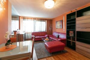 - un salon avec un canapé rouge et une table dans l'établissement Zentrales Apartment in U-Bahn Nähe & Hauptbahnhof, à Vienne