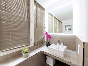 bagno con lavandino e specchio di LivinParis - Luxury 4 Bedrooms Le Marais I a Parigi