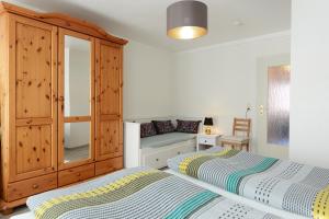 a bedroom with two beds and a cabinet at Fürstenhof Apartment Wismar in Wismar