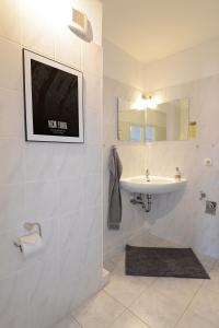 a bathroom with a sink and a tv on the wall at Fürstenhof Apartment Wismar in Wismar